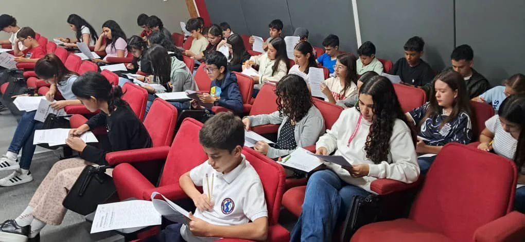Students reviewing tournament papers in an auditorium