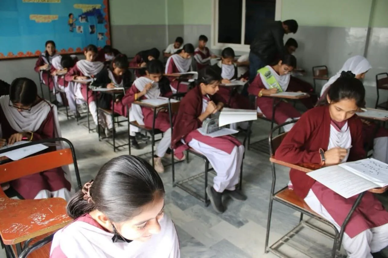 A classroom of students focused on their papers