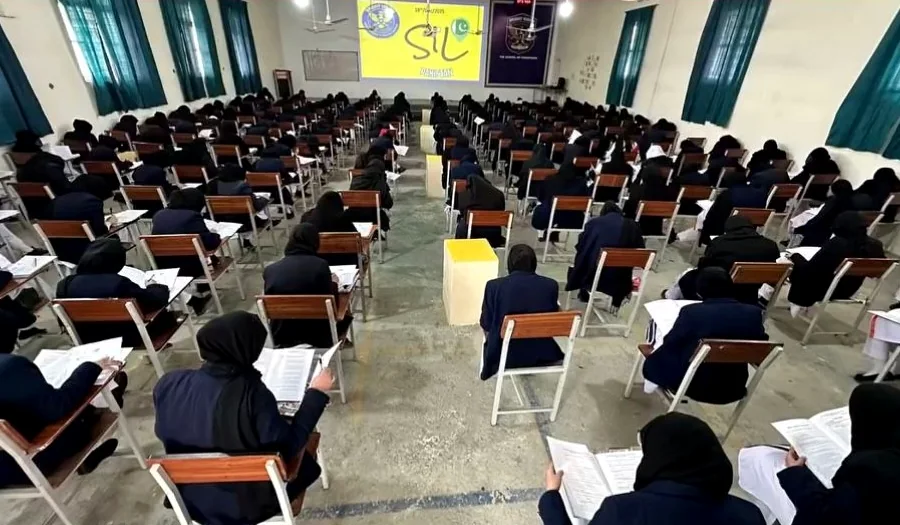 A large hall of scholars completing a national-round paper