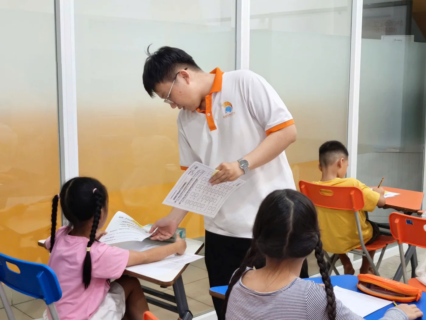 An invigilator assisting a young scholar during a paper