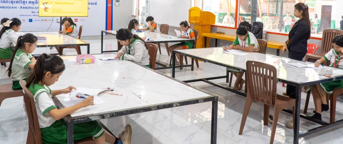 Students seated around classroom tables during a national round