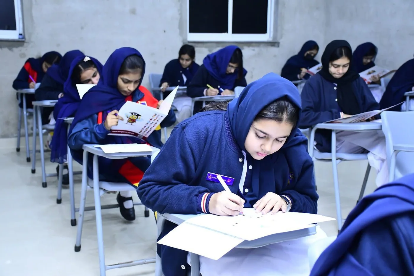 Young scholars completing written papers in a classroom