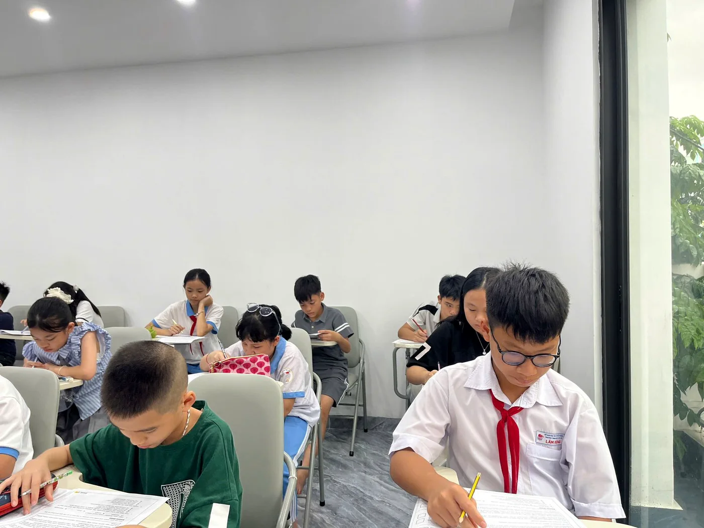 Young scholars writing papers in a modern classroom